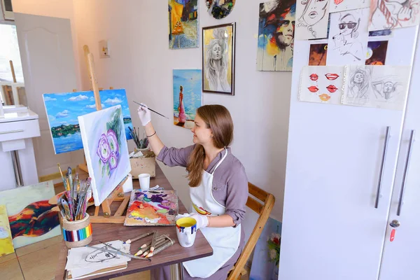 Girl Sits on Stool at Easel And Writing Painting, Uses Brush to — Stok Foto