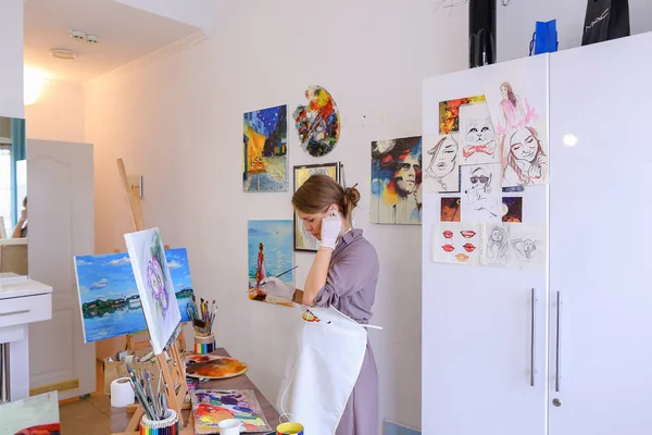 Schöne junge Malerin malt Bild verwendet Pinsel und Öl, und — Stockfoto