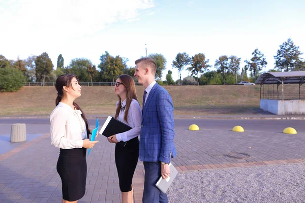 Three young successful businessman, students communicate, smilin