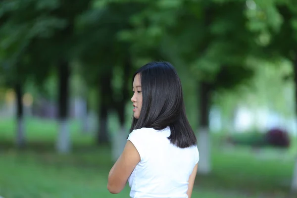 Mladá dívka v parku jsou pěší chůzí — Stock fotografie