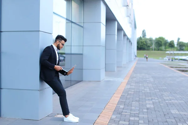 Cool chico árabe hombre utiliza el ordenador portátil en el centro de negocios — Foto de Stock