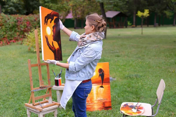 Artista mulher segura pintura e olha para ele, posando para câmera e — Fotografia de Stock