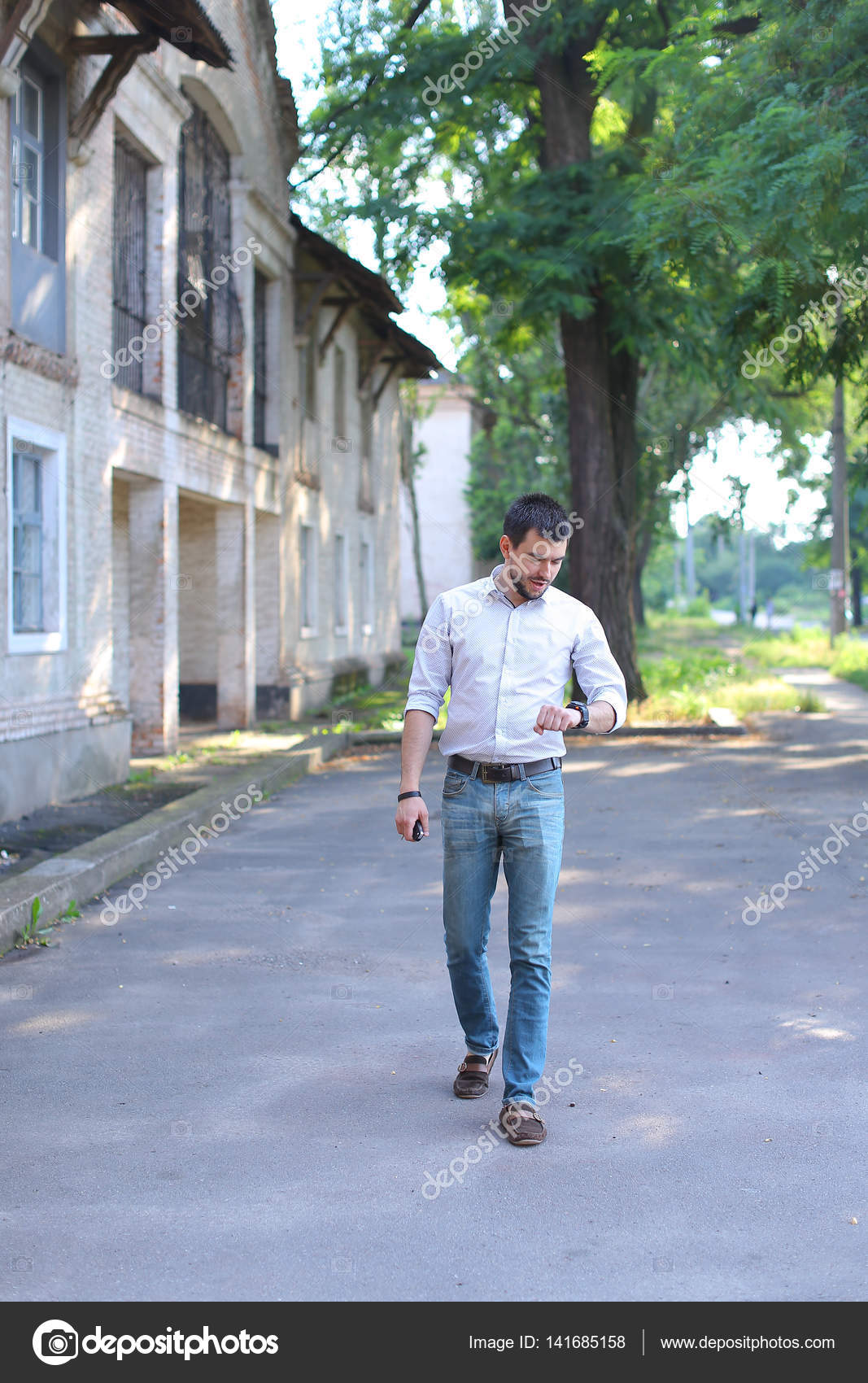 Handsome Young Man Going Walking Along Road And Looks At Watch Stock Photo Image By C Sisterspro Handsome Young Man Going Walking Along Road And Looks At Watch Stock Photo Image By C Sisterspro