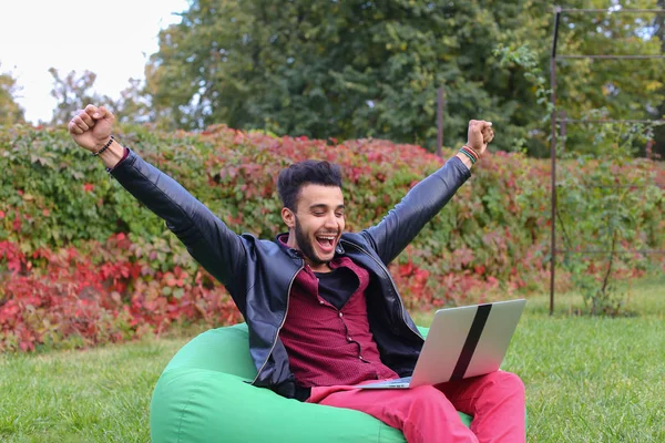 Framgångsrika arabiska ung affärsman sitter med Laptop i stol, S — Stockfoto