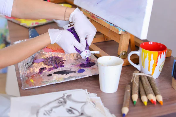 Художник экструдирует краску из трубок на палитре для смешивания цветов t — стоковое фото