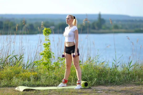 Atlet žena vážené rameno nohy cvičení pod širým nebem — Stock fotografie