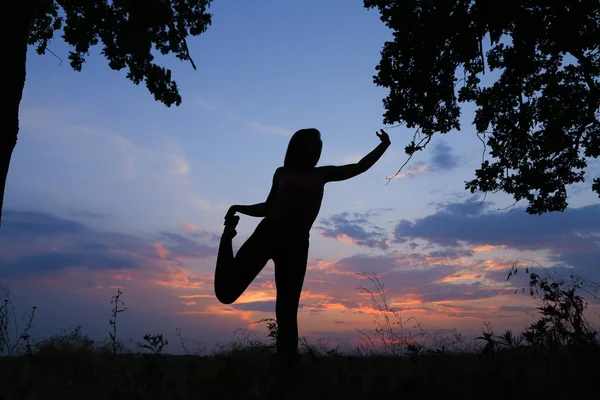 Smal tjej visar olika poser och dans i fältet utomhus på — Stockfoto