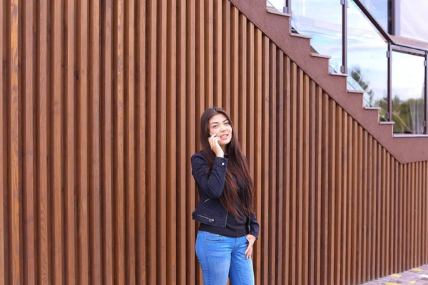 Linda mulher de cabelos escuros segura no telefone mão e falando, smi — Fotografia de Stock