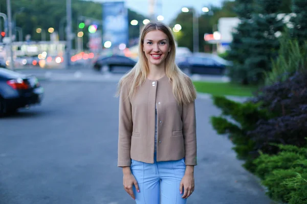 Симпатичная молодая женщина улыбается, позирует перед камерой и стоит на ба — стоковое фото