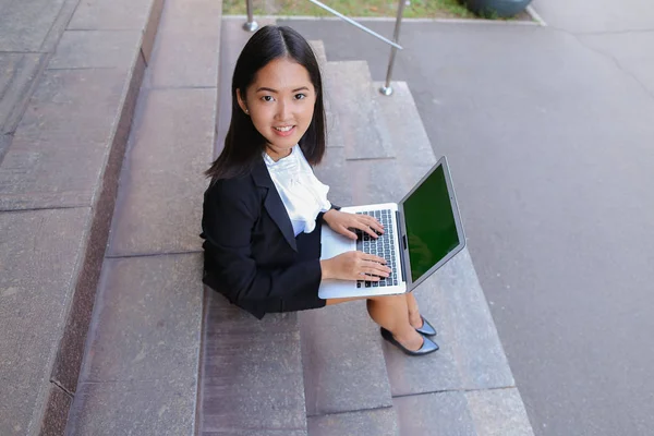 Asian beautiful young female holds in hands laptop and smiling,l