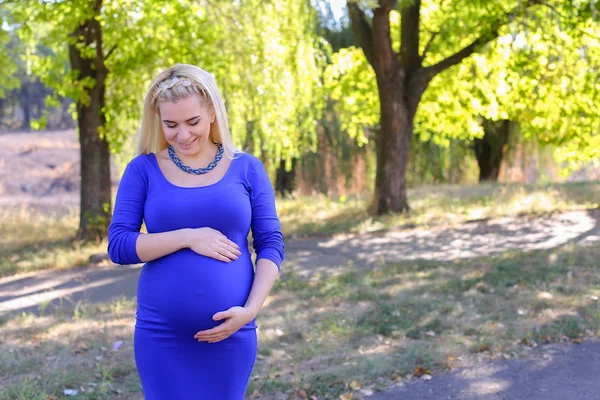 Ładny Blond ciąży matka chodzenie na słoneczny dzień w parku, Stop — Zdjęcie stockowe