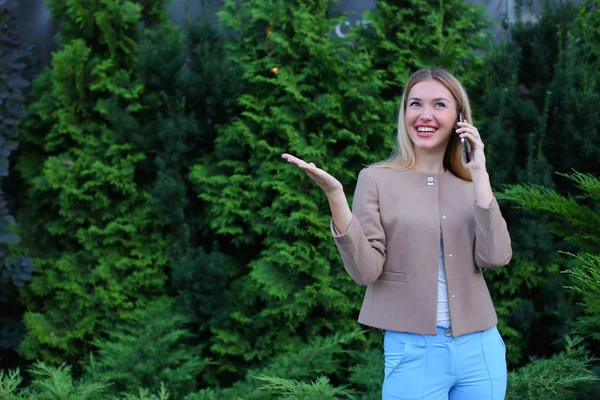 Atractiva dama rubia hablando por teléfono y lo sostiene en la mano, smi — Foto de Stock