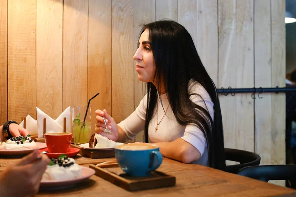 Chica bonita hablando, escuchando, comiendo y sonriendo en la mesa en c — Foto de Stock