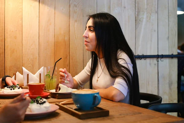 Pretty girl talking, listening, eating and smiling at table in c — Stock Photo, Image