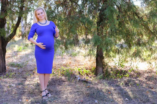 Güzel genç gelecekte anne jest gösterir ve başparmak yukarı yükseltir,