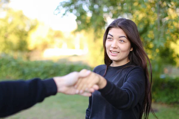 Preto de cabelos bonito menina segurando em braços comprimento cara mão, sorrindo — Fotografia de Stock