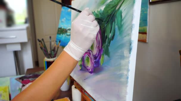 Primer plano de las manos de una joven artista pintando con pincel retratando flores en el estudio de arte . — Vídeos de Stock