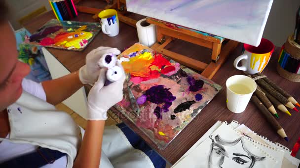 射击的材料圆盘和女性艺术家的手的特写镜头，改变管和油漆推入调色板. — 图库视频影像