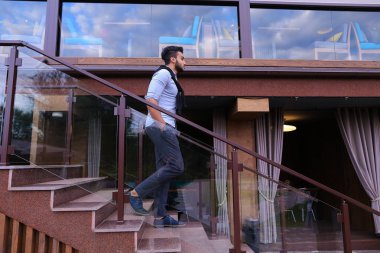 Genç Müslüman adam standsin tam uzunlukta gülümseyen ve ha ile poz