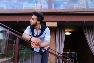 Meme üzerinde ha eğilerek yakışıklı erkek Arap görünüm gülümseyen genç