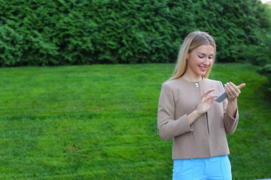 Güzel erkek Smartphone ekran ve gülümsüyor, seyir standları