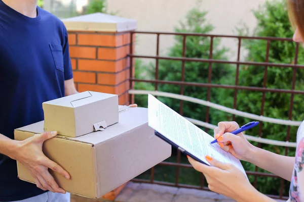 Man Courier traz ordem para o cliente, dá caneta e papel para Sig — Fotografia de Stock