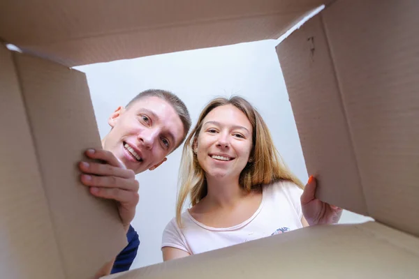 Hombre y mujer abrió la caja, miró dentro de la caja, feliz, saliendo de un — Foto de Stock