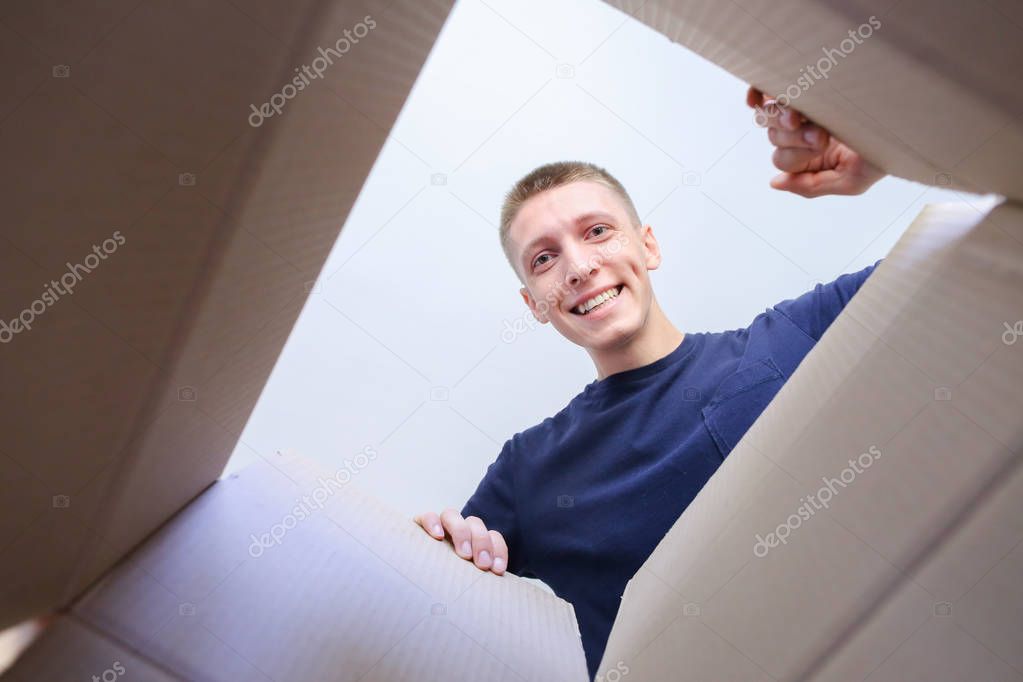 Man Opens Box Smiling Stretching His Arms to Inside of Enclosure