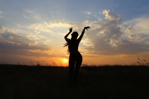 Slim girl showing various poses and dancing in a field outdoors — Stock Photo, Image