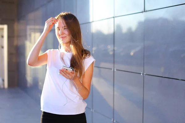 Una joven adulta bonita estudiante mujer de negocios sostiene telepho — Foto de Stock