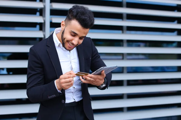 Young arabic man uses tablet  online order shopping in business