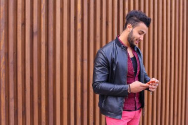 Şık genç adam elinde tutan sakallı ve kullandığı telefon smart,