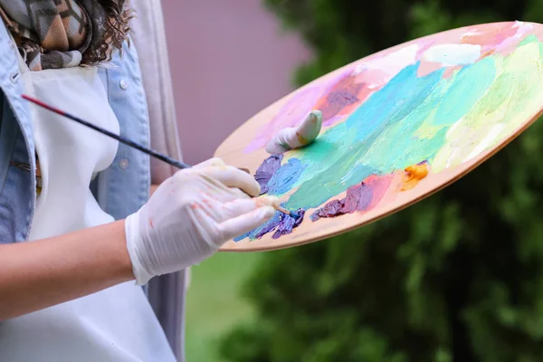 Mulheres artistas mão espremida de tubos de tinta a óleo em madeira pálida — Fotografia de Stock