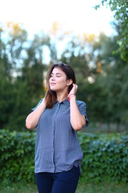 Güzel kadın kamera, sevimli seyir gülümseme ve saç düzeltir