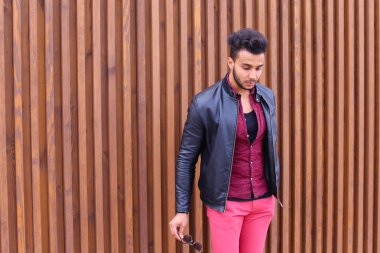 Etkileyici Arapça genç adam inceler ve gözlük ceket düzeltir