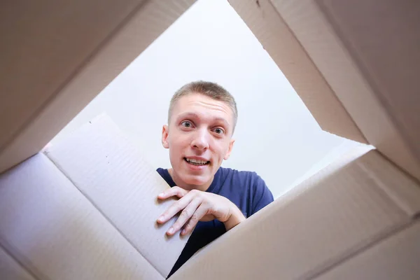 Hombre abre la caja sonriendo y estirando sus brazos al interior de Encl — Foto de Stock