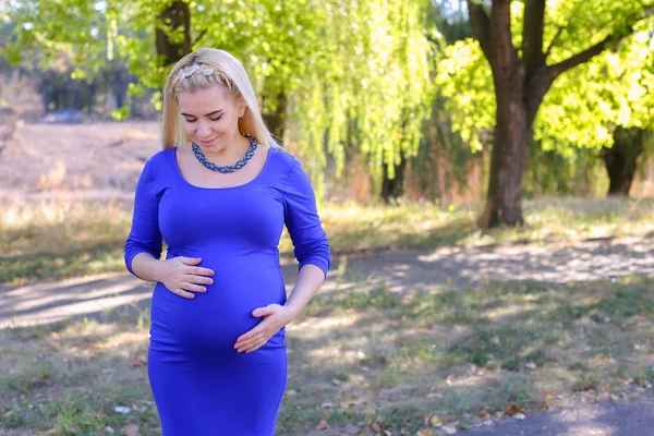 Madre bastante rubia embarazada caminando en el día soleado en el parque, parada —  Fotos de Stock