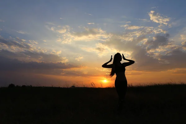 Karcsú lány mutatja a különböző pózok, és táncol egy mező a szabadban — Stock Fotó