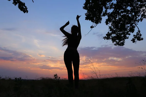 Štíhlá dívka ukazuje různé pózy a tančí v poli venku na — Stock fotografie