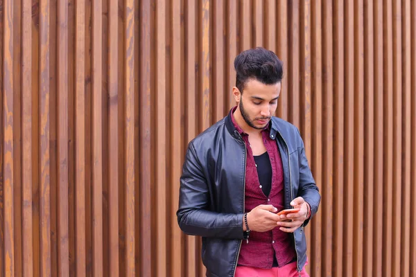 Élégant barbu jeune homme tenant dans les mains et utilise un téléphone intelligent , — Photo