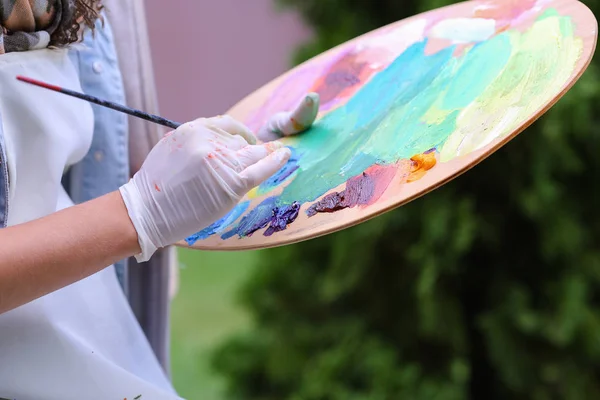 Mujeres artistas exprimidas a mano de tubos pintura al óleo sobre madera pálida —  Fotos de Stock