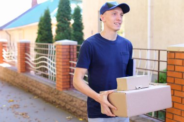 Postacı yakaladığında parsel arka plan kameraya gülümseyen elinde