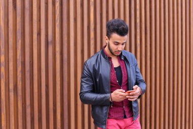 Şık genç adam elinde tutan sakallı ve kullandığı telefon smart,