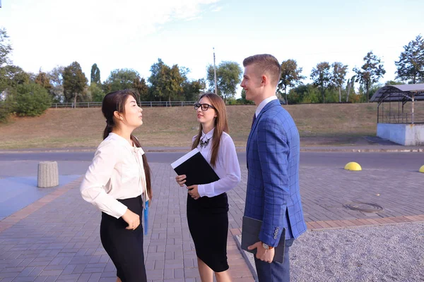 Three young successful businessman, students communicate, smilin