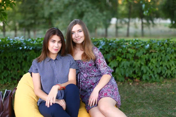 Twee mooie meisjes zitten naast elkaar in de stoel, smilin — Stockfoto