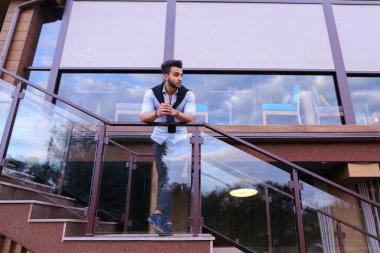 Genç Müslüman adam tam uzunlukta gülümseyen ve st poz duruyor