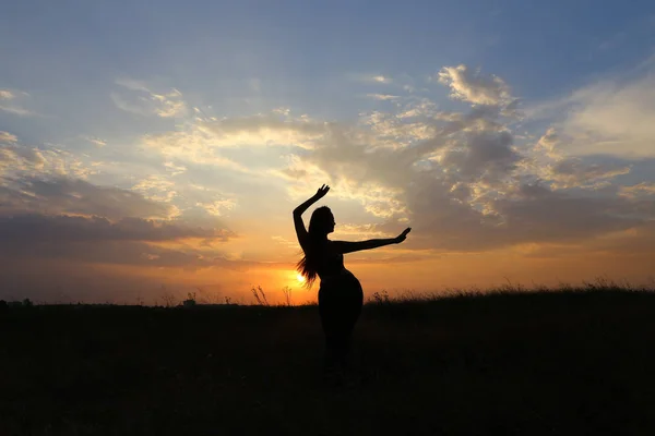 Karcsú lány mutatja a különböző pózok, és táncol egy mező a szabadban — Stock Fotó