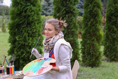 Güzel Avrupa görünüm sanatçı paleti ve fırçalar tutar bir