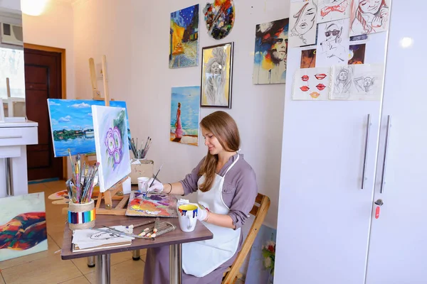 Girl Sits on Stool at Easel And Writing Painting, Uses Brush to — Stok Foto