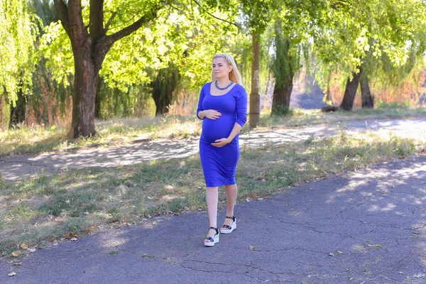 Sarışın bekleyen anne güneşli Park, Stop yürüyüş — Stok fotoğraf